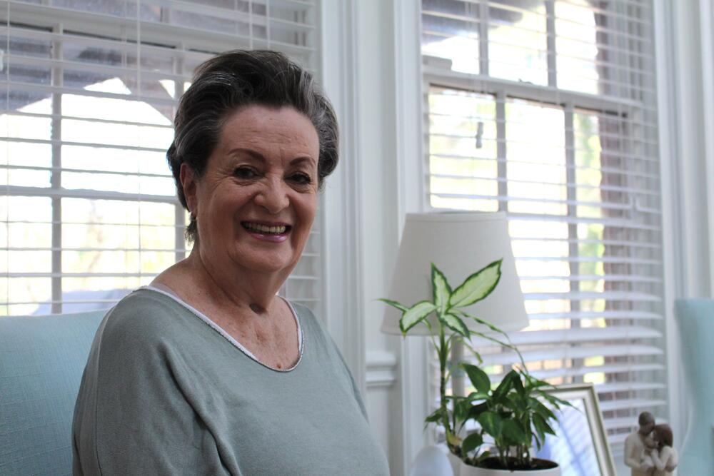 Luz Ospina poses for a photo in her living room