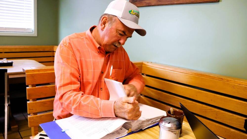 Rusty Blackston sorts through his binder of notes and paperwork about the Brightmark Thomaston Circularity Center at a restaurant in Thomaston in April 2025. Kala Hunter  