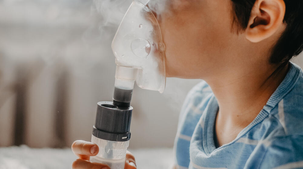 Young child using nebulizer.