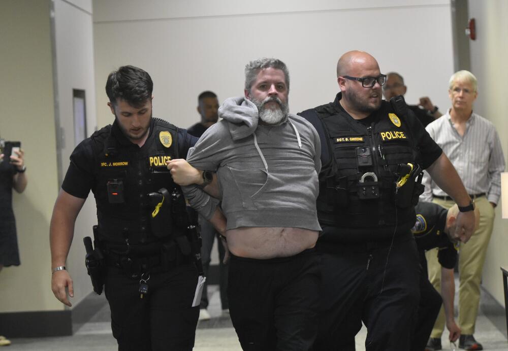 A man is arrested during an April town hall for Congresswoman Marjorie Taylor Greene. Fiery town halls have become the norm, and some lawmakers are opting to avoid them altogether. Ross Williams/Georgia Recorder