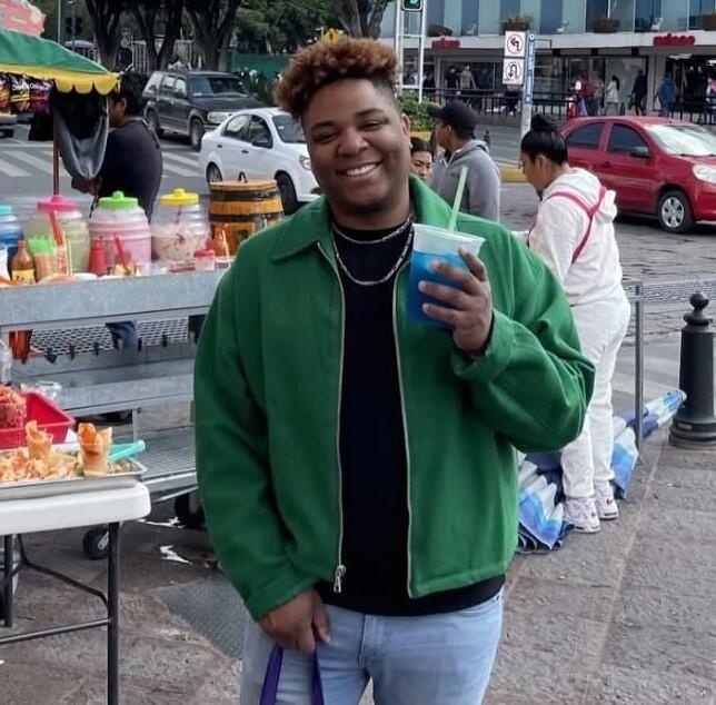 Chris Allen Villegas Fentress is shown holding a blue drink in an outdoor location.