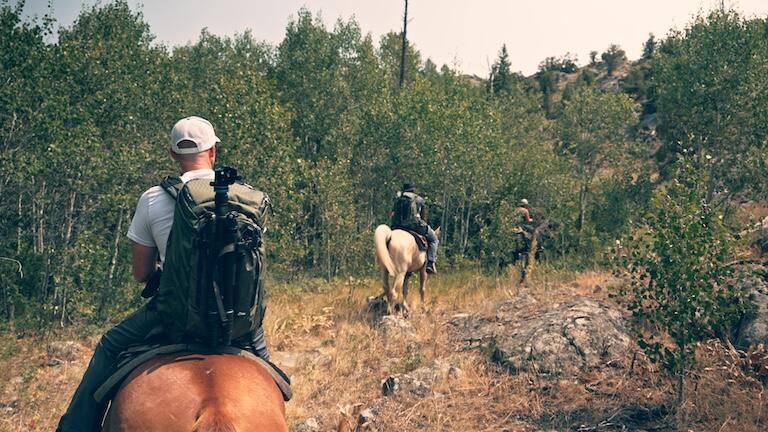 Three people on horseback.