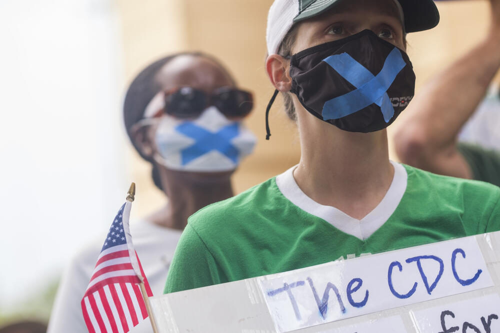 Some current CDC employees at the protest wore surgical masks with blue masking tape to symbolize what some called their inability to speak out about changes art the CDC.