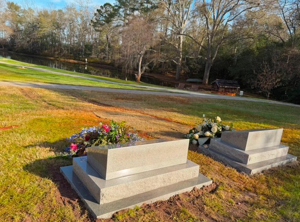 Images of President and Mrs. Carter’s final resting place: two headstones with flowers with pond in background. Jimmy Carter National Historical Park/Facebook