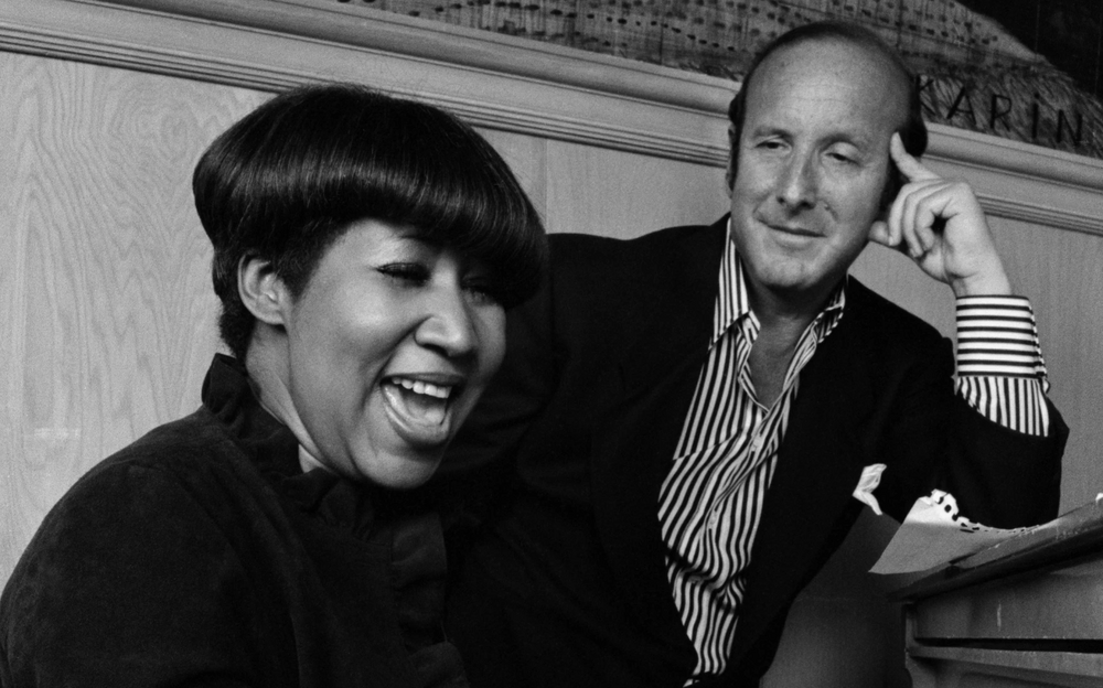 Clive Davis and Aretha Franklin at a piano.