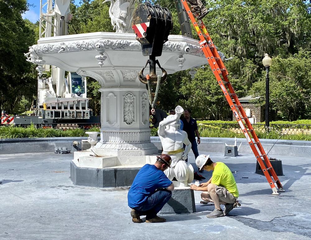 Workers prepare one of the fountain's four triton statues for removal by crane.