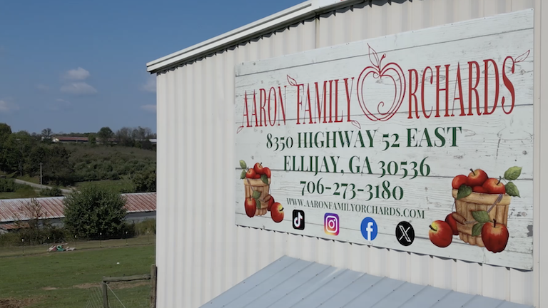 A sign on a building that says, "Aaron Family Orchards."