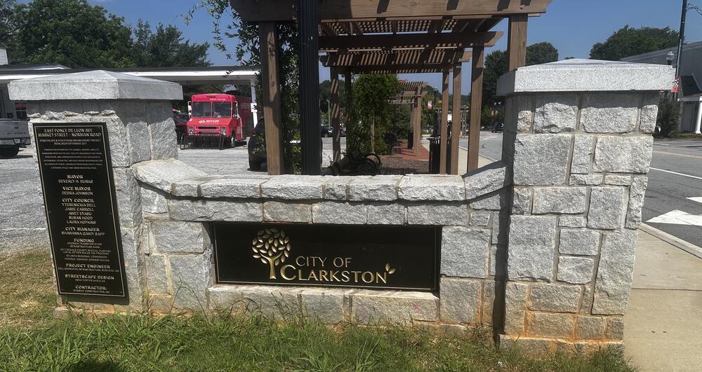 A City of Clarkston sign, with the Refuge Coffee truck visible in the background.