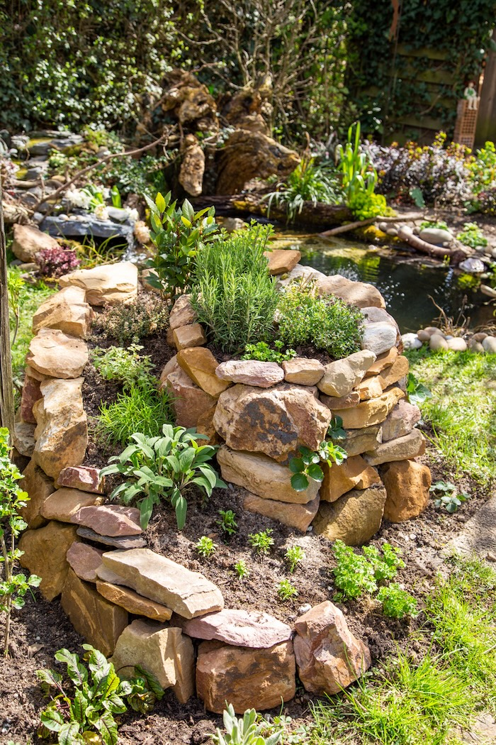 A garden of herbs is styled into a lawn landscape feature called a spiral or snail