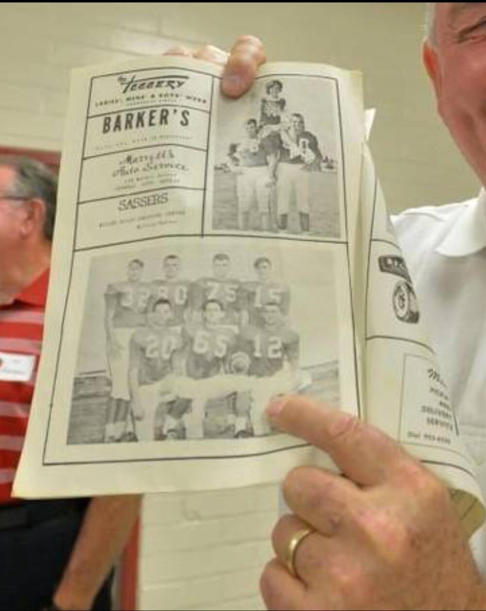 Sonny Perdue poses with a photo of him during his football days.