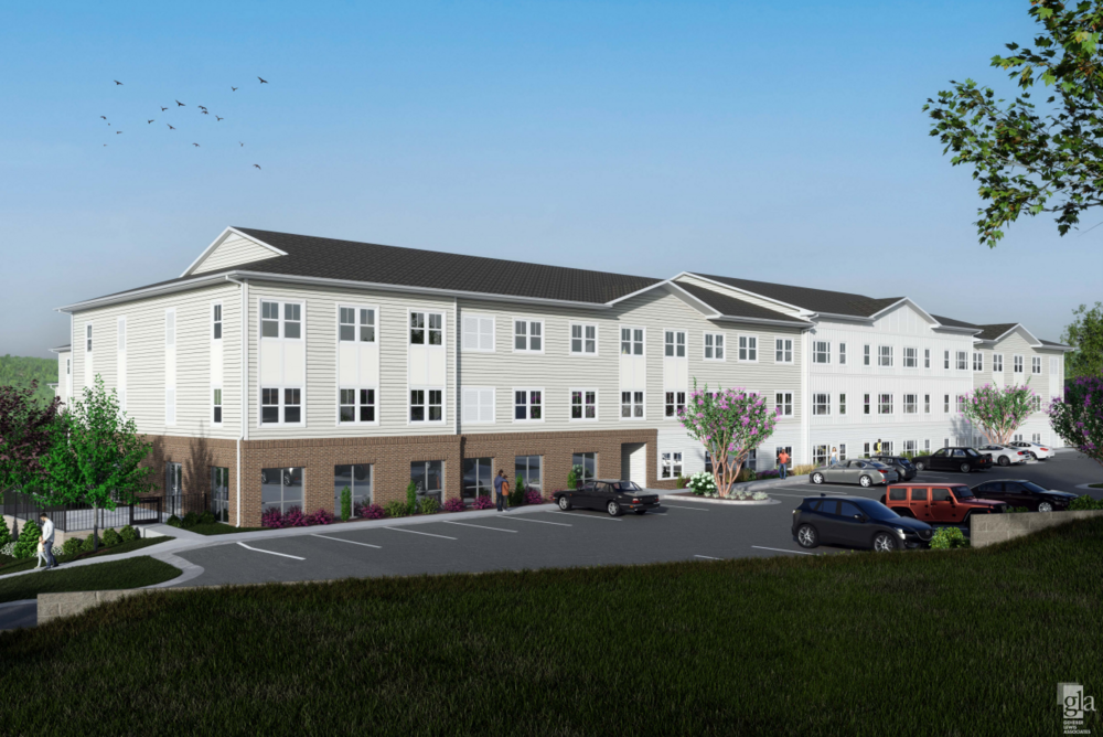 A three story white apartment building and a parking lot.