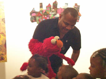 Elmo hobnobs with kids from Sheltering Arms at the science and arts education announcement.