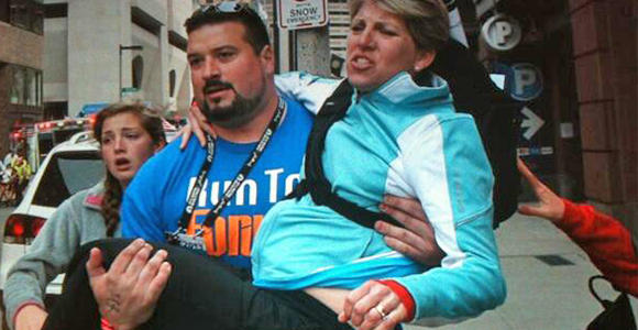 Former New Englands Patriot Joe Andruzzi helps a bombing victim.  Photo courtesy Twitter.