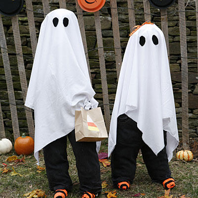 A pair of trick-or-treaters in homemade ghost costumes