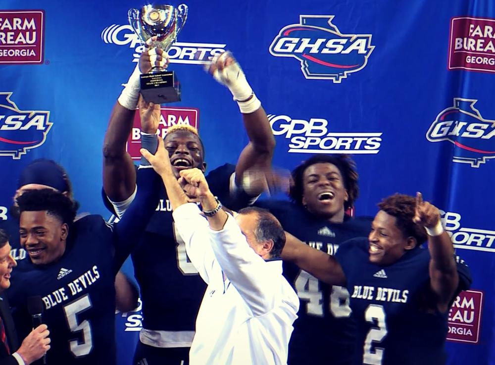 The Norcross Blue Devils hoist the 2013 Class AAAAAA state title trophy.