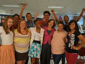 Anne Ostholthoff smiles alongside students from Columbus High School in the premiere episode of The Ignite Show.