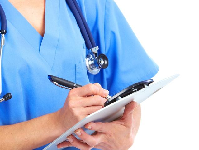 A medical practitioner holds a clipboard.
