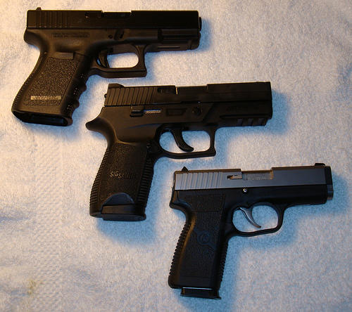 Three handguns on a white background