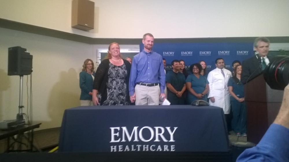 Discharged Ebola patient Dr. Kent Brantly stands at a press conference with his wife 