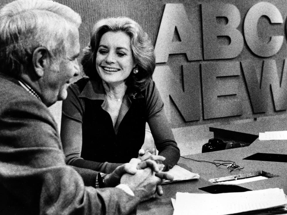 Barbara Walters chats with co-host Harry Reasoner following her debut on ABC's evening news program in New York in October 1976. She was the nation's first female news anchor and the first anchor to take home a seven-figure salary.