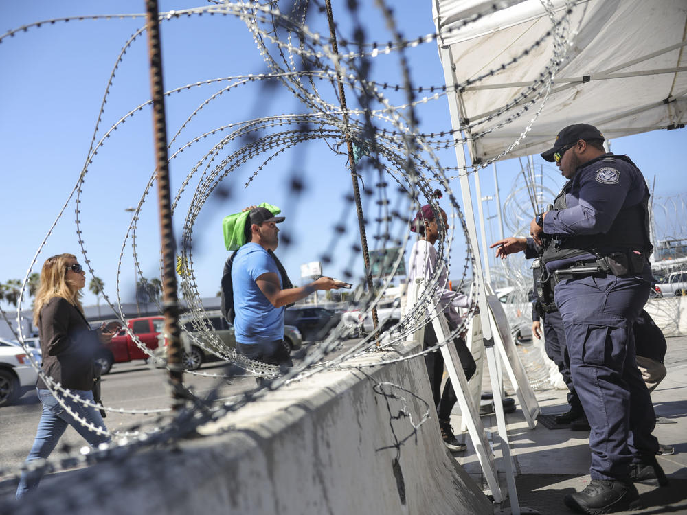An Immigration and Customs Enforcement agent checks pedestrians' documentation at the San Ysidro Port of Entry in San Ysidro, Calif., on Oct. 2.