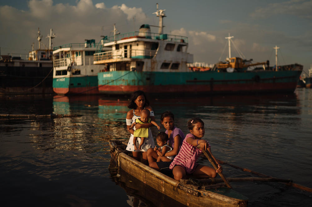 Sisters Joan (center) and Jossa Garcia (left), both teen mothers, hang out in a boat with their children and their younger sister. Each year, 1.2 million Filipina girls between the ages of 10 and 19 have a child.