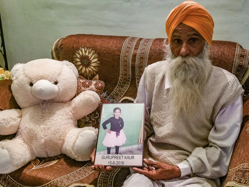 Gurmeet Singh holds a photo of his granddaughter, Gurupreet Kaur, who died of heatstroke in Arizona in June 2019. The 6-year-old and her mother had just crossed into the U.S. from Mexico.