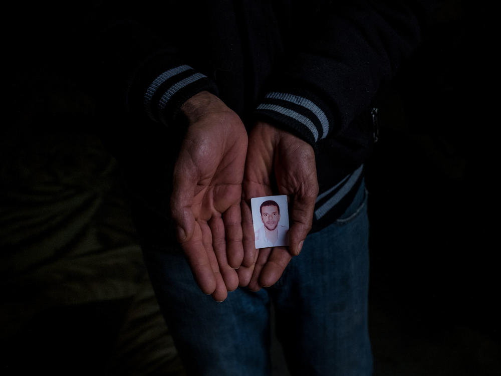 Jilani Hablani holds a portrait of his son, Abdelwaheb Hablani, at his home in Jelma, Tunisia. In December 2019, Abdelwaheb Hablani, 25, self-immolated and died. He was working as a day laborer but had not been paid in nearly two years.
