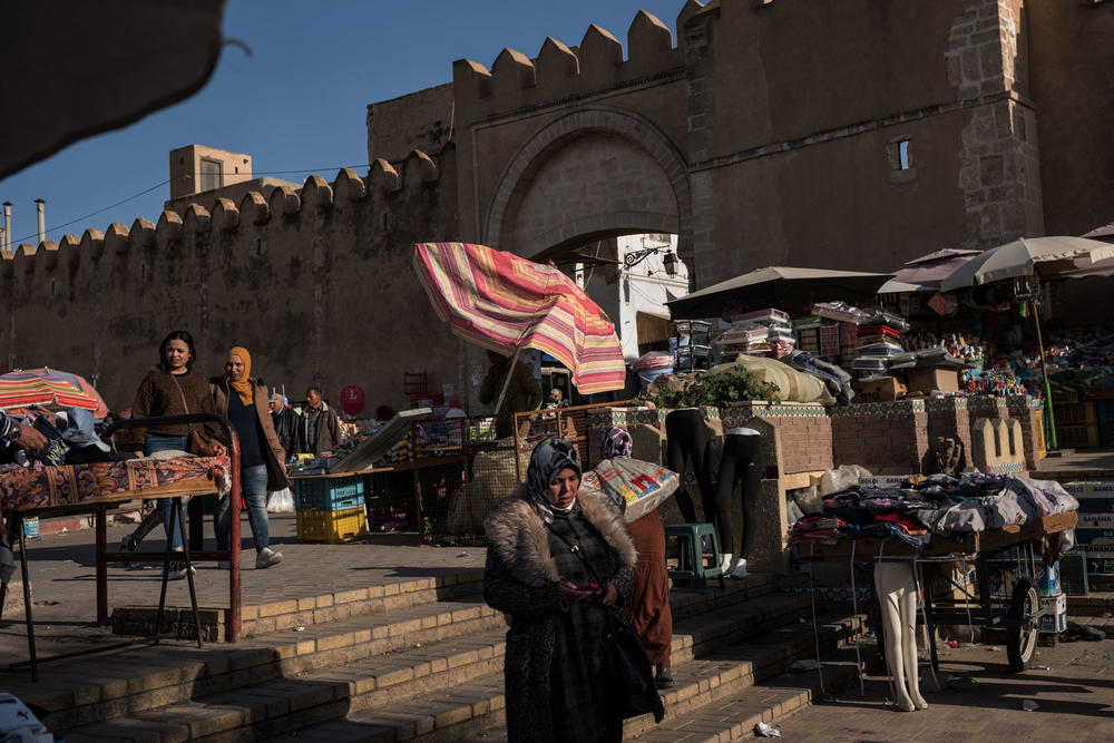 An outdoor market selling produce, household items and second-hand clothing is seen outside the entrance to Sfax. Second-hand sellers have become more common in Tunisia as people haven't been earning enough to buy new goods or are selling their own things.