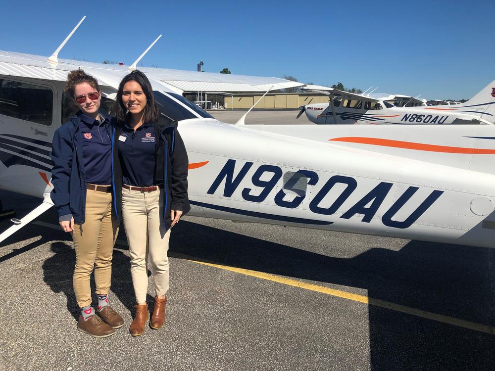 Elizabeth White (L) and flight instructor Megan Brown stand by a Cessna 172 after a training flight in Auburn, Ala.