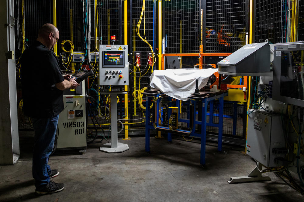 Dan Tasiemski, director of general assembly at the Lordstown Motors assembly plant in Ohio, works to revive a robot on the assembly floor of the factory.