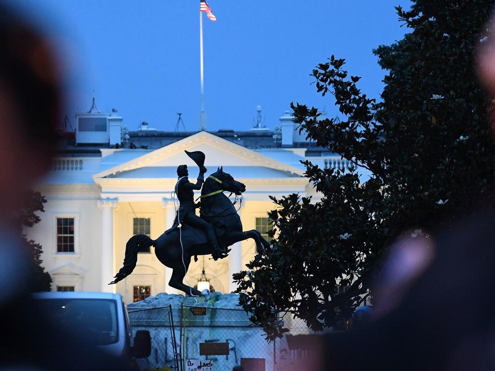 Police officers stand guard with the statue of former President Andrew Jackson after protesters tried to topple it Monday in Lafayette Square in Washington, D.C.