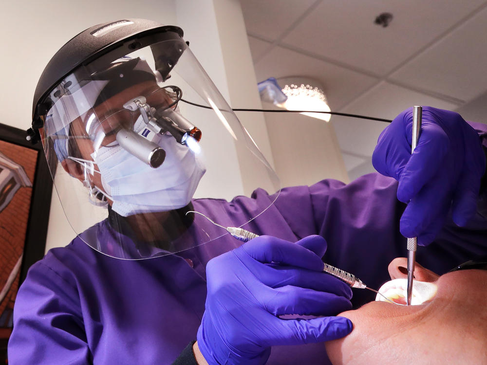 Dental offices have begun seeing patients return for routine procedures. Seattle dentist Kathleen Saturay has increased the layers of protective equipment she wears when treating patients.