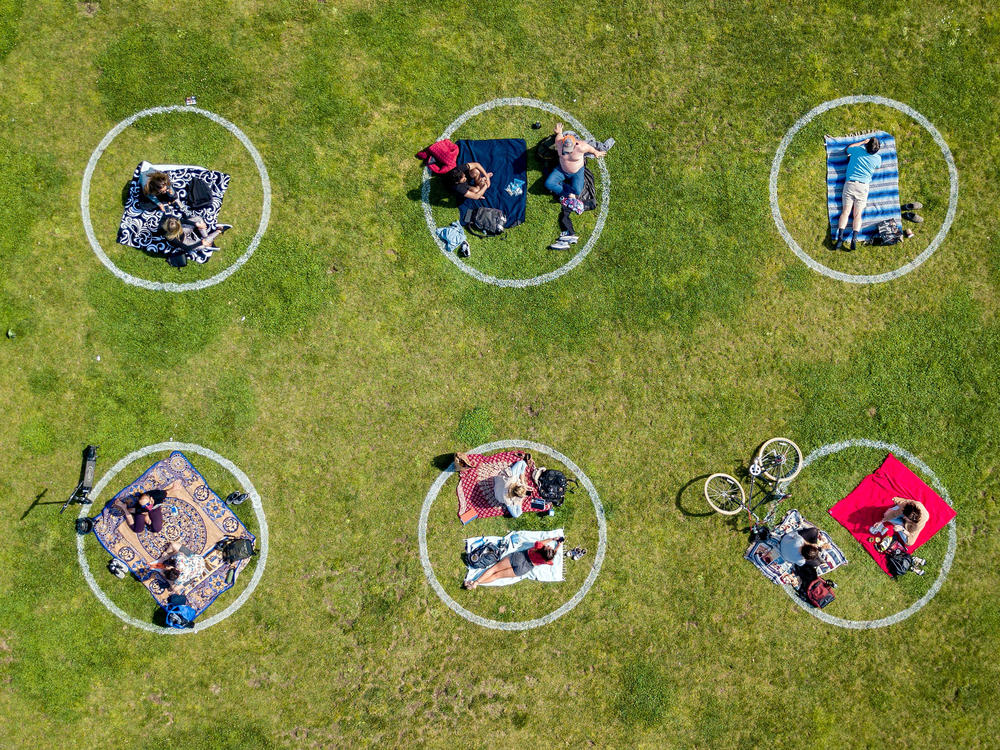 Communication skills used to negotiate safe sex are also useful for setting boundaries while socializing during the COVID-19 pandemic. Above, circles drawn in the grass encourage social distancing at Dolores Park in San Francisco.