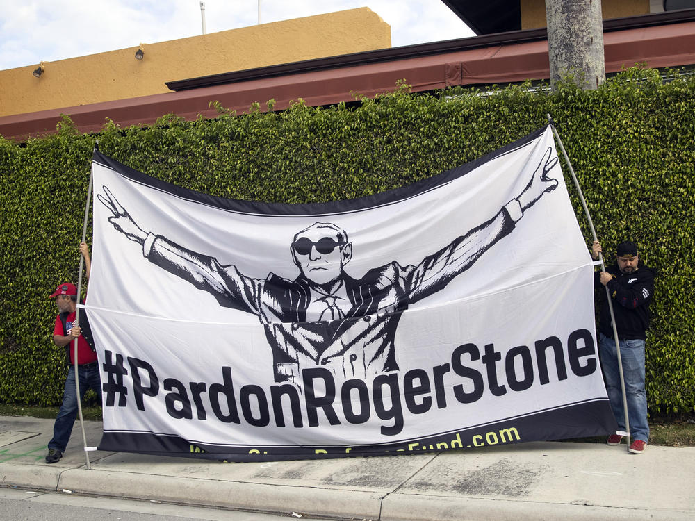 Activists display a sign in support of Stone as President Trump's motorcade heads to Palm Beach International Airport in March in West Palm Beach, Fla.