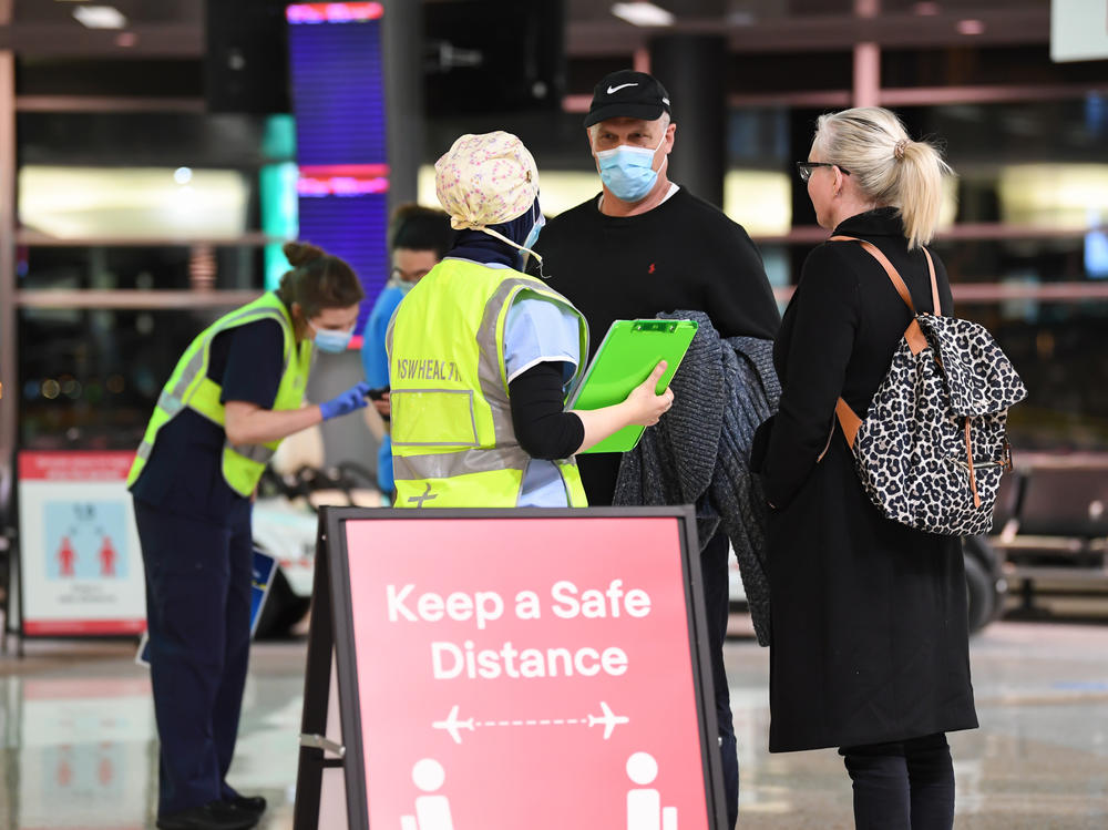 New South Wales health officials interview passengers as they arrive from a Qantas flight that flew from Melbourne at Sydney Airport in July.