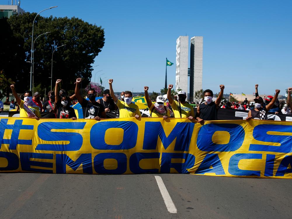 Demonstrators carry a banner that says, 