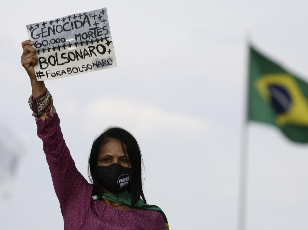 A women's movement activist holds a sign that reads in Portuguese 