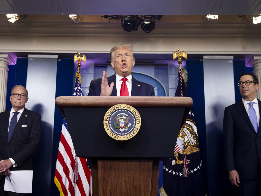 President Trump speaks as Treasury Secretary Steven Mnuchin (right) and Larry Kudlow, director of the National Economic Council, listen during a news briefing on July 2.
