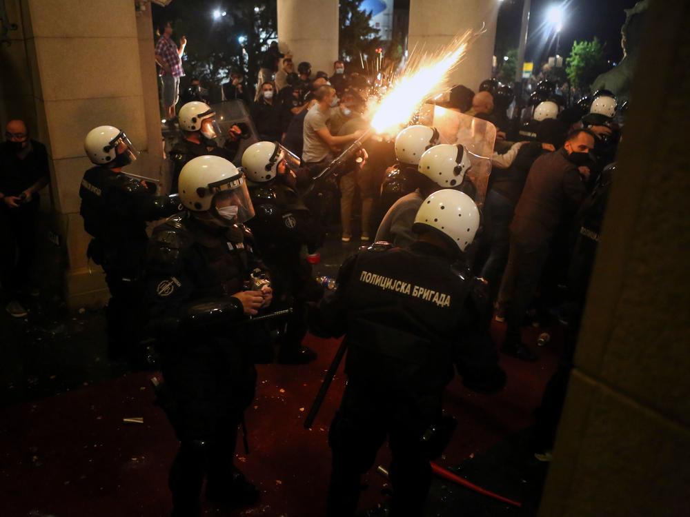 Protesters clash with police Tuesday night in front of the National Assembly building in Belgrade, Serbia.