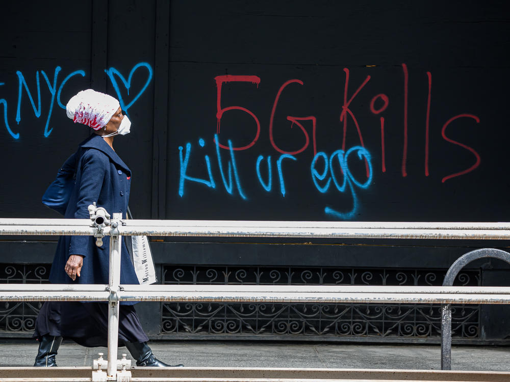 A pedestrian walks past anti-5G graffiti in the Flatiron District of New York in May.