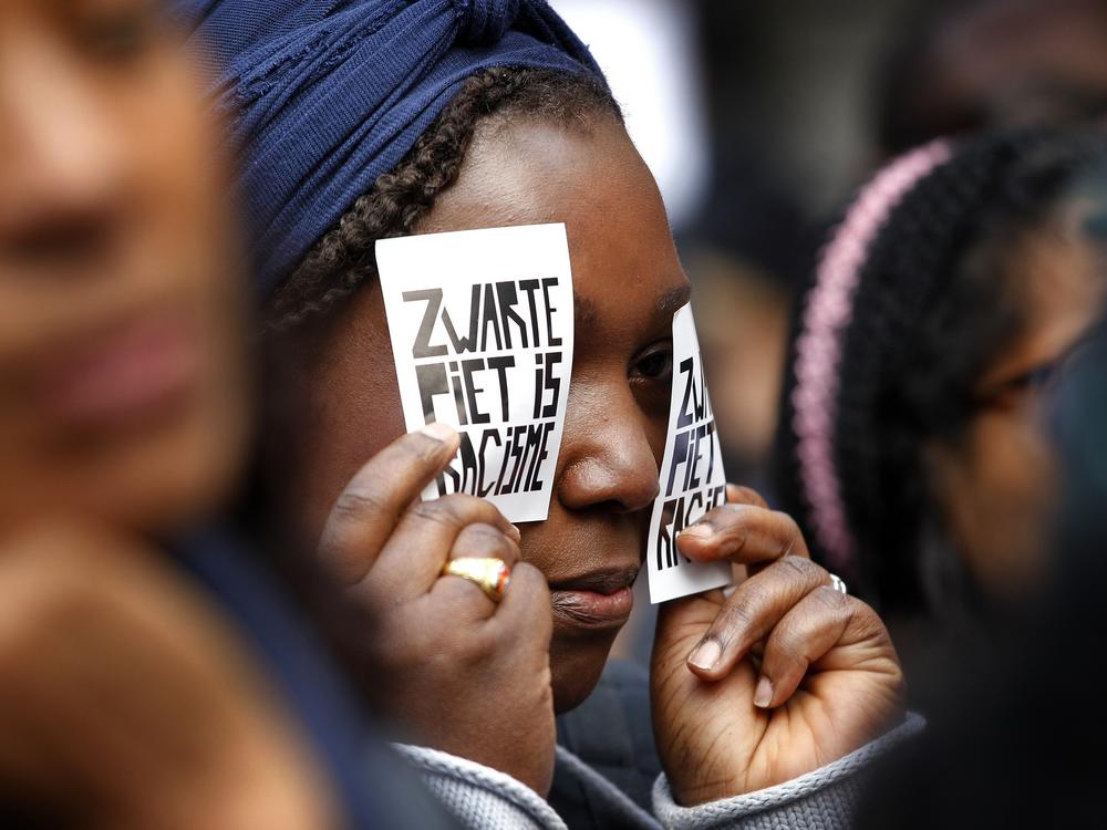 A demonstrator holds a sign reading 