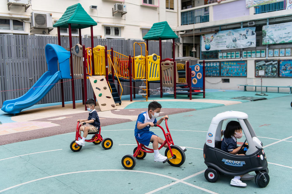 Primary school students enjoy recess at a distance from each other, with masks in place.