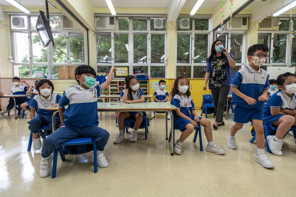 Children and staff wear masks inside a classroom.