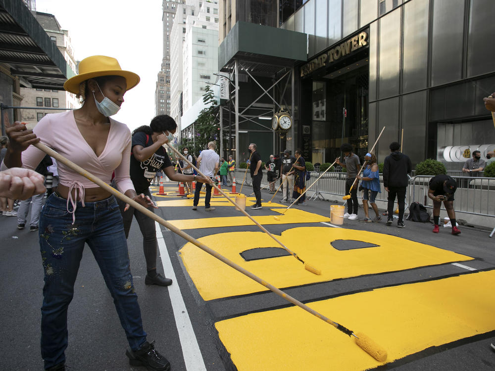 Azia Toussaint helps paint a Black Lives Matter mural on Fifth Avenue in front of Trump Tower on Thursday in New York.