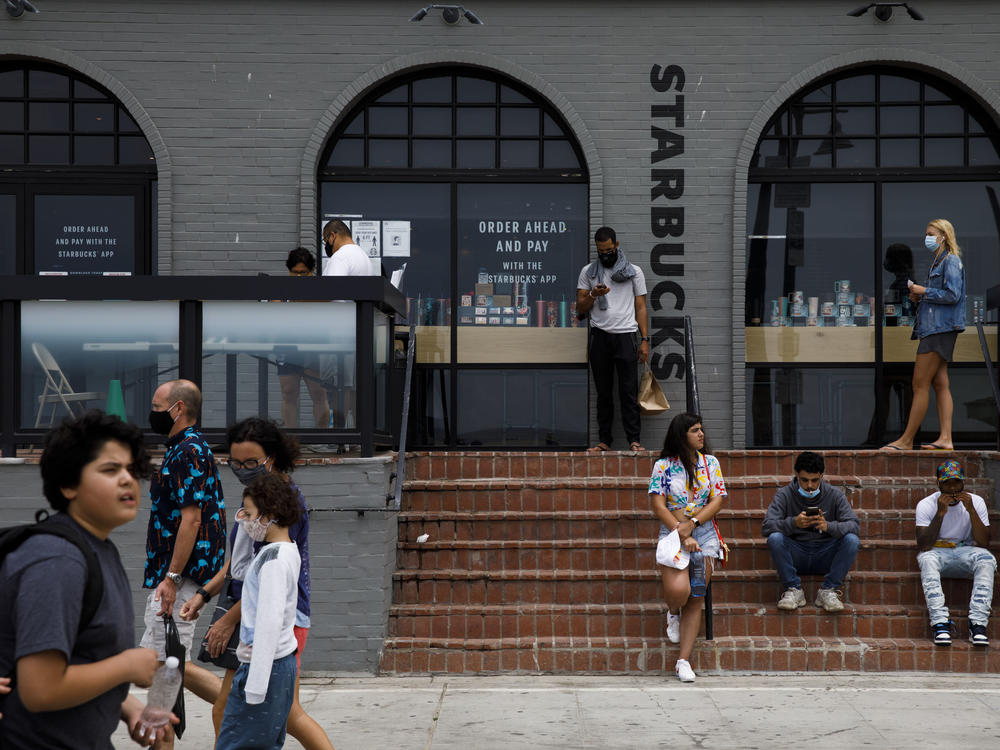 People gathered outside of a Starbucks coffee shop at Venice Beach in Los Angeles last month. The company's order for all customers to wear masks will take effect on July 15.