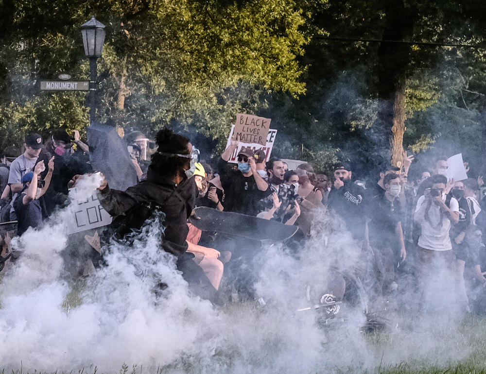 Protesters participating in a peaceful demonstration react to being hit by Richmond Police with tear gas and pepper spray on Monument Avenue at the Robert E. Lee statue on June 1, about 30 minutes before the city's curfew.