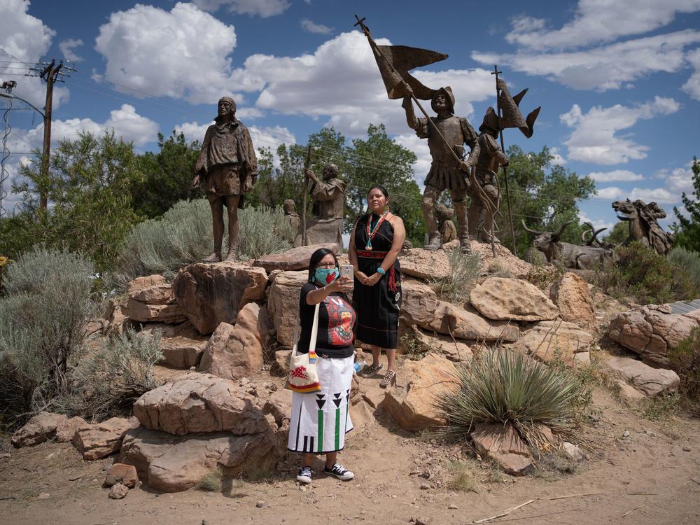 Channing Concho, left, and American Horse photograph themselves in front of a memorial after a sculpture of Spanish conquistador Juan de Onate was removed on June 16, 2020 in Albuquerque.