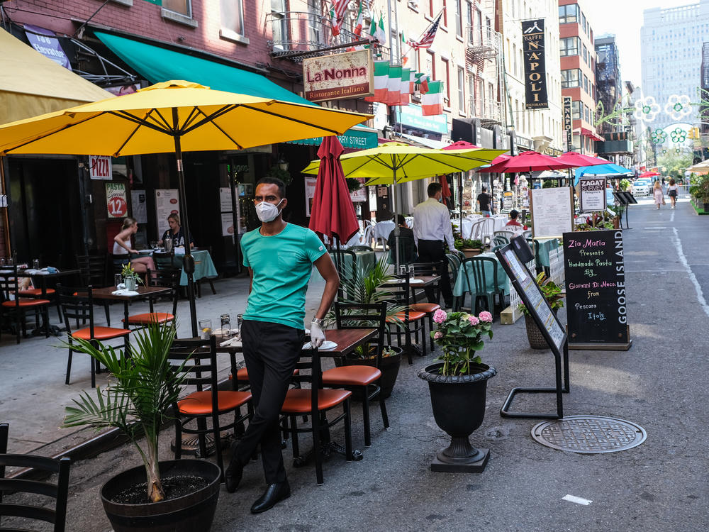 New York City had its first 24-hour period since March without a death from the coronavirus on Saturday. Here, people dine outdoors on July Fourth in Manhattan's Little Italy.