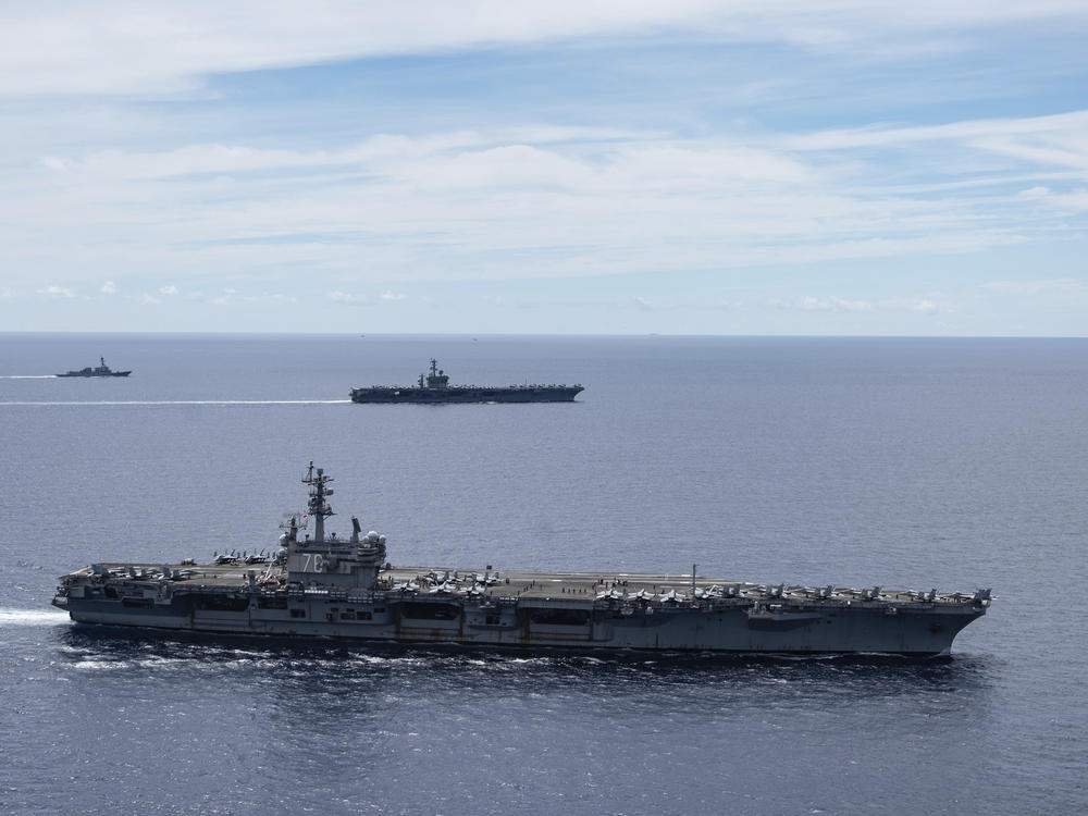 The USS Ronald Reagan (foreground) and the USS Nimitz Carrier Strike Groups sail together in formation in the South China Sea on July 6. China has accused the U.S. of flexing its military muscles by conducting joint exercises with two U.S. aircraft carrier groups in the strategic waterway.